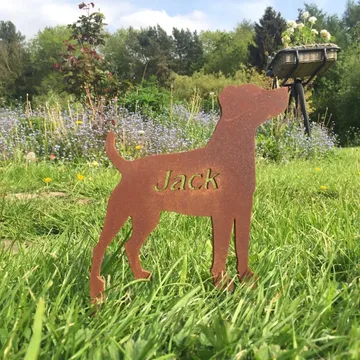 A laser-cut steel memorial marker engraved with the name Jack, in a garden